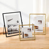 Three modern floating picture frames display minimalist art and natural elements on a wooden surface.