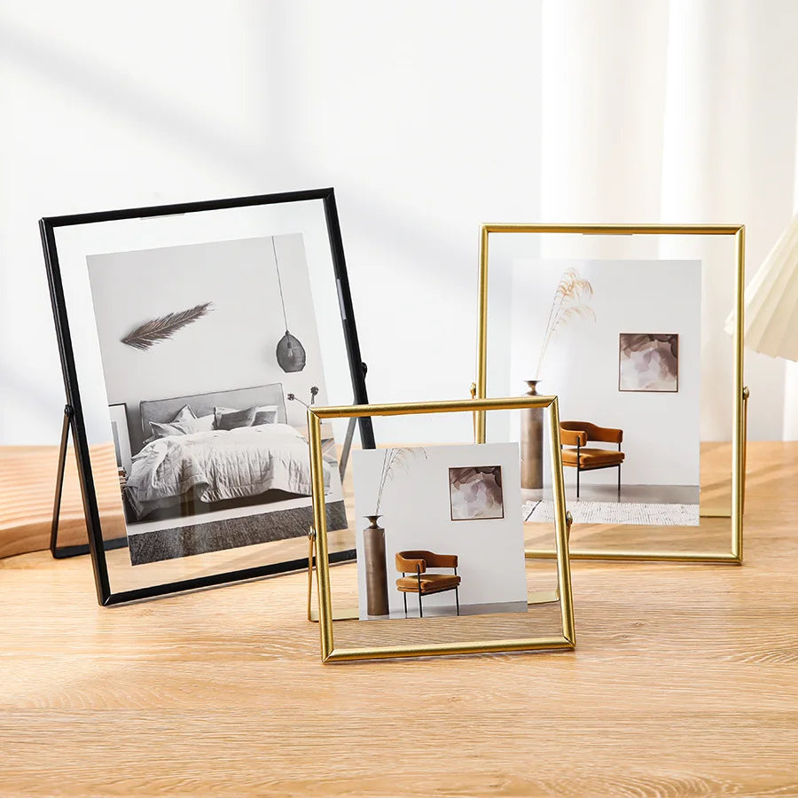 Three modern floating picture frames display minimalist art and natural elements on a wooden surface.
