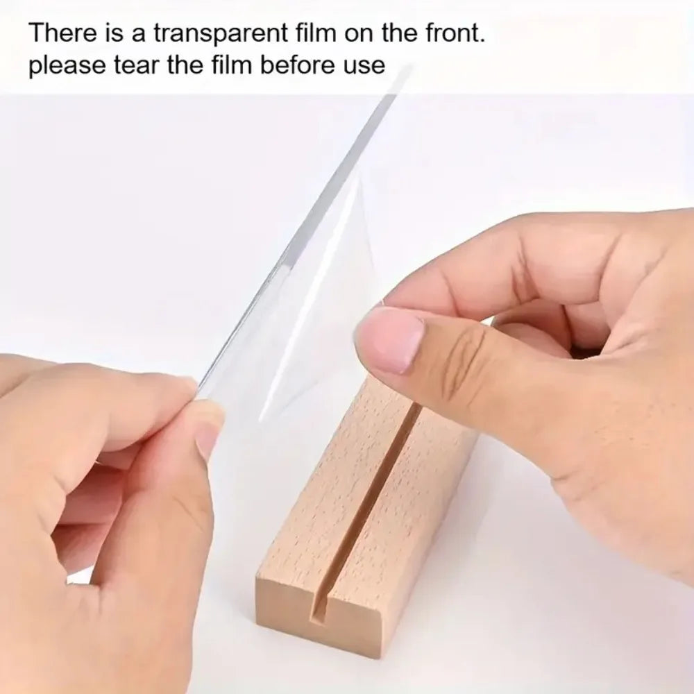 A hand is tearing a transparent film off a wooden desktop meditation statue for use.