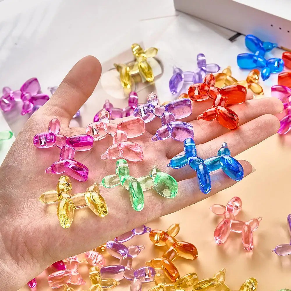 Eine Hand hält eine Sammlung farbenfroher Mini-Kristallballonornamente in verschiedenen Schattierungen wie rosa, lila, gelb u