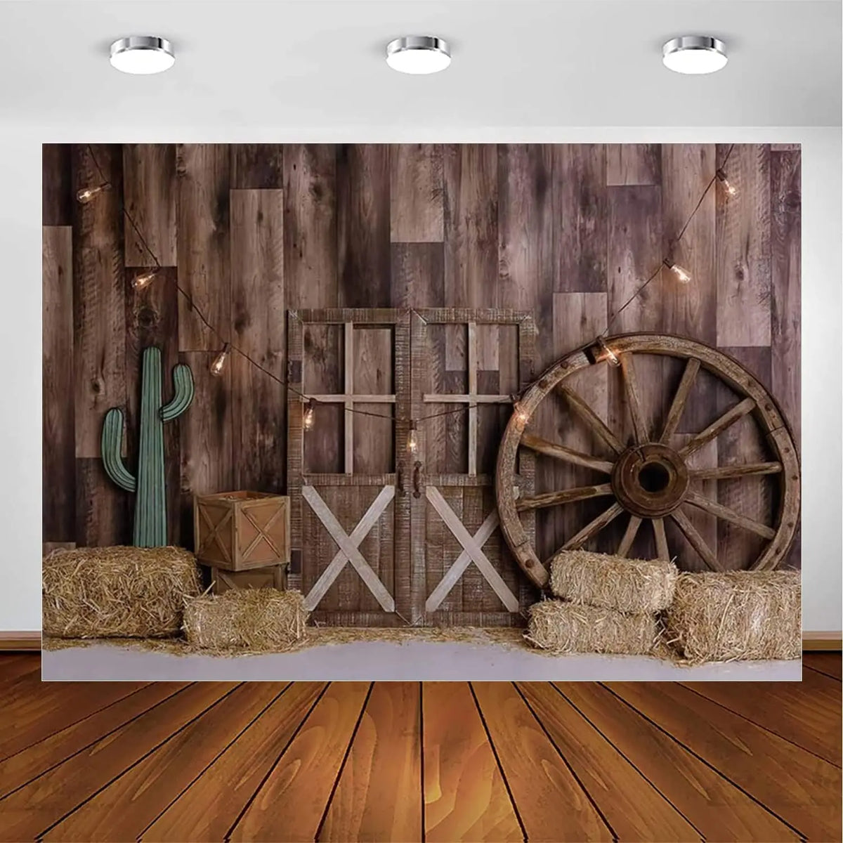 A rustic western backdrop featuring a wooden barn door, a cactus, and a large wooden wagon wheel.