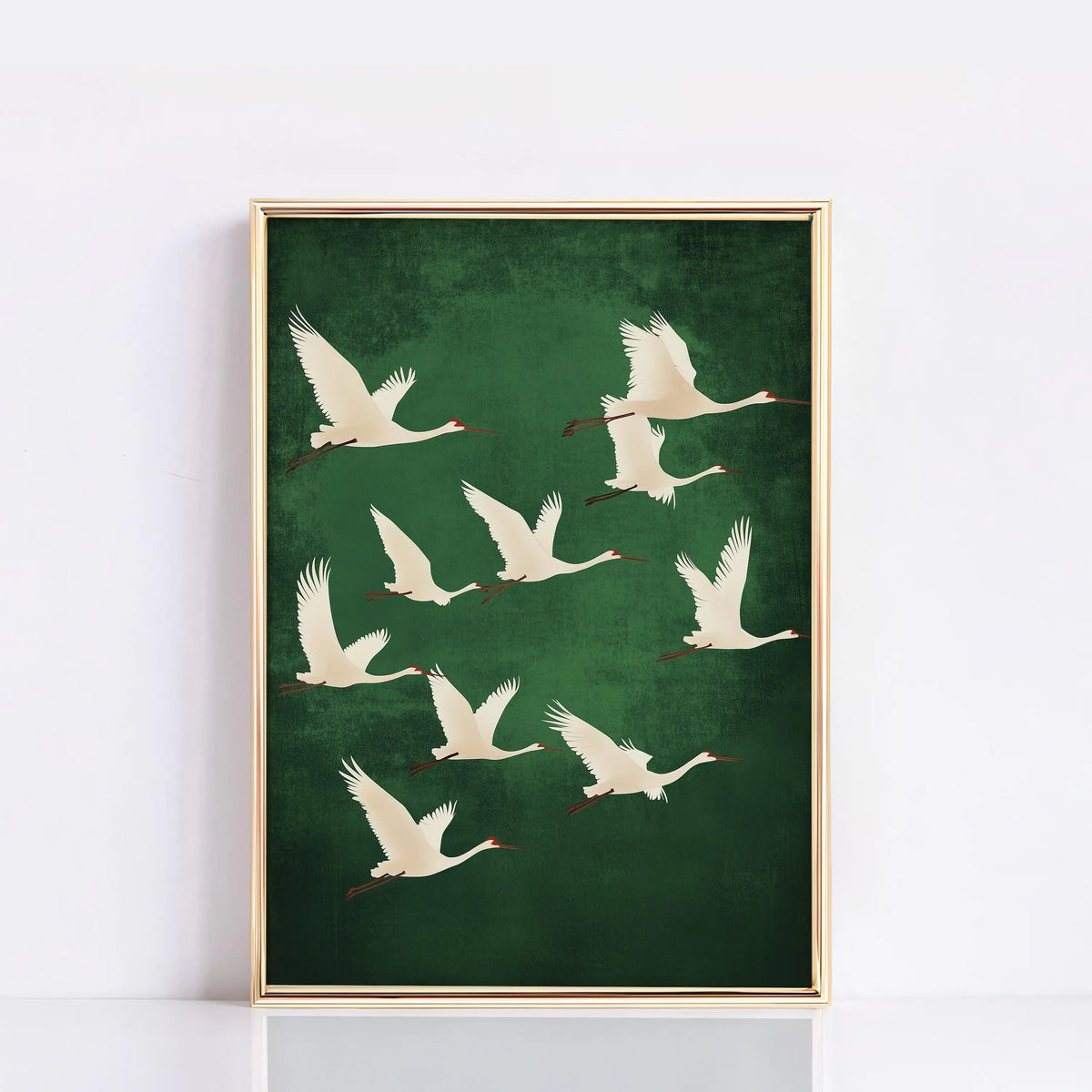 A framed canvas wall art featuring several white cranes in flight against a dark green background.