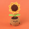 Handmade crochet sunflower desk companion with a smiling face, featuring orange petals and a brown center.