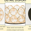Detail display showing a round gold metal candle holder, a crystal surround, and a black bottom plate.
