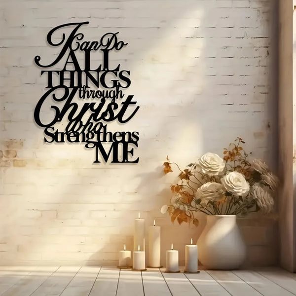 Black script wall art featuring the verse "Fan Do All Things through Christ strengthens me" displayed on a white brick wall.