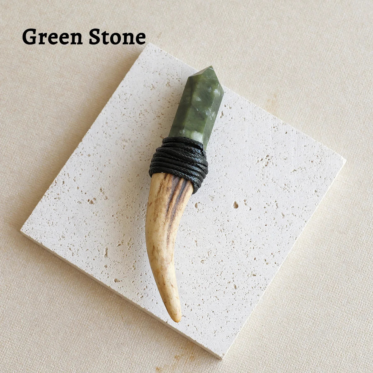 A green stone scepter wand with a wooden tip and black cord wrapped handle displayed on a white square surface.