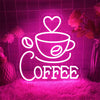 A neon LED wall sign shaped like a coffee cup and the word COFFEE glowing bright pink against a dark background.