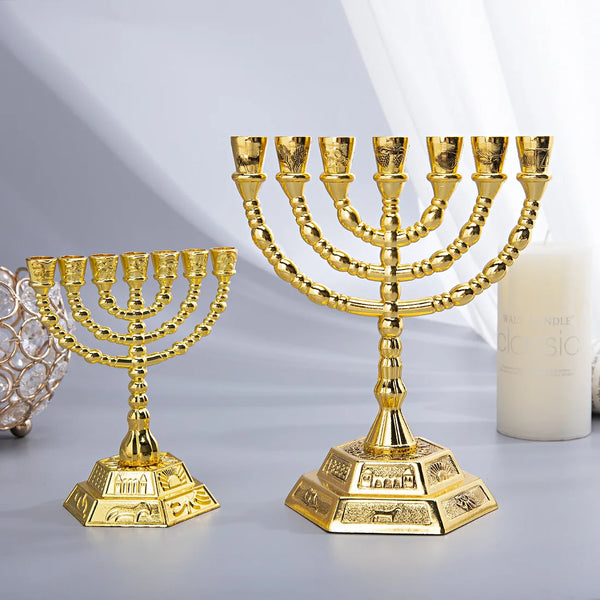 A gold 7-branch Menorah candle holder with a decorative base is displayed on a gray surface.