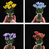 Handmade glass flower bouquets featuring yellow, blue, and purple tulips in clear glass vases.