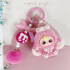 A pink fluffy heart plush keychain charm with a pink ring and a pink ribbon on a light pink background.