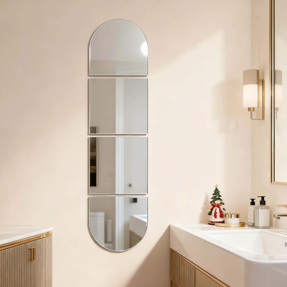 A vertical oval acrylic mirror with multiple rectangular sections mounted on a light beige wall.