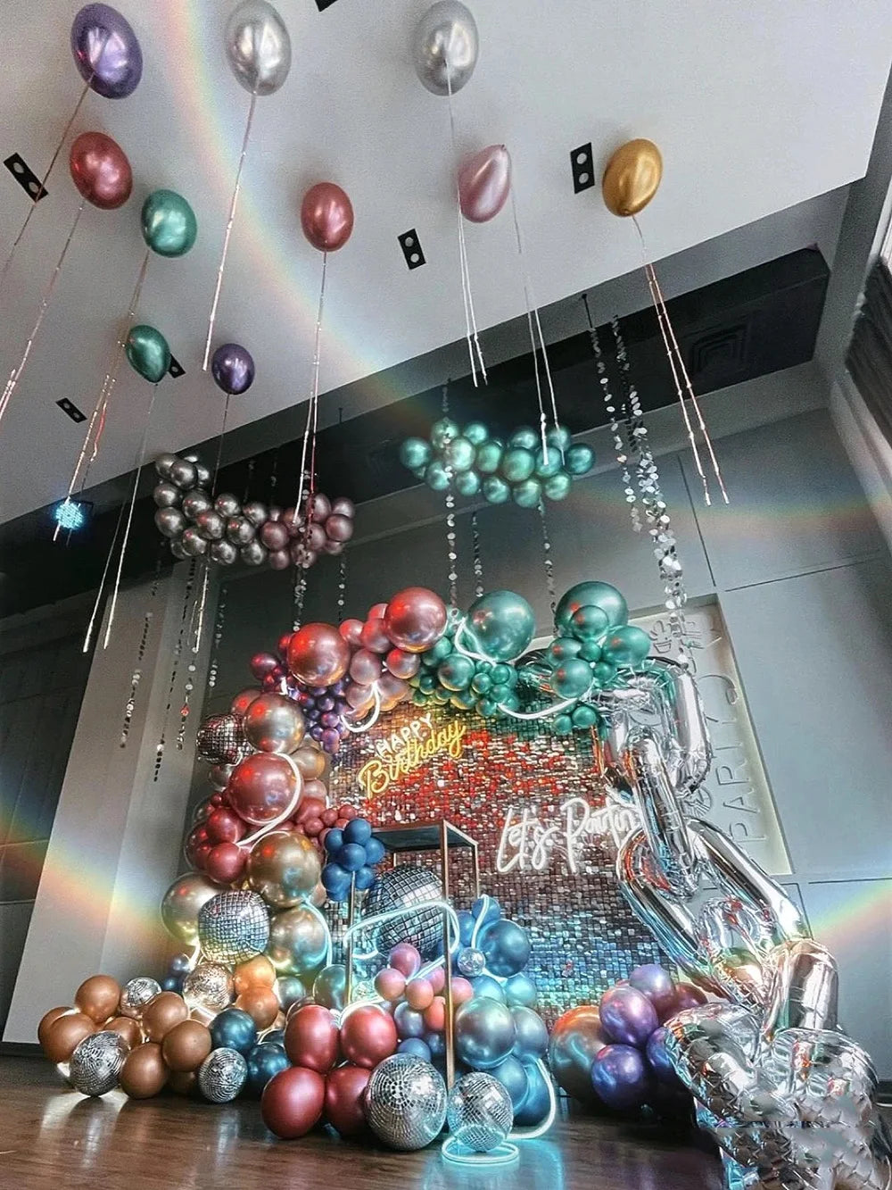 A display of chrome metallic latex balloons in various colors like gold, silver, purple, and green for party decor.