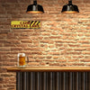 A vintage metal wall sign with yellow lettering reading Camp Crystal Lake mounted on a brick wall above a wooden bar.