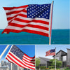 A large 3x5 foot American party bunting flag waving against a blue sky and ocean backdrop.