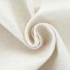 A close-up of cream-colored, textured fabric folded into a swirl.