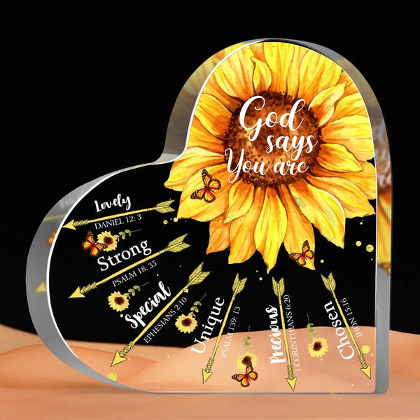 A heart-shaped glass plaque with a sunflower design and Bible verses like God says you are strong and special.