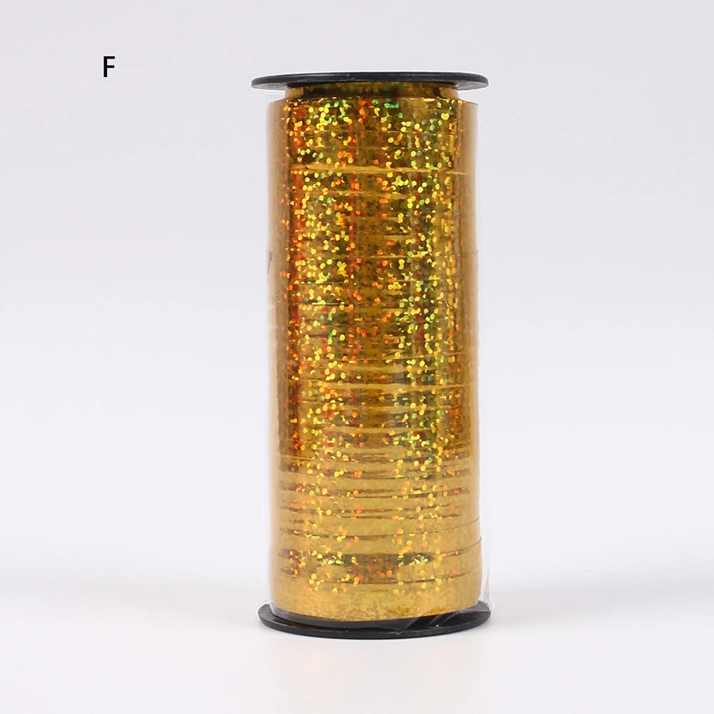 A roll of gold glitter curling ribbon used for gift wrapping and party decor.