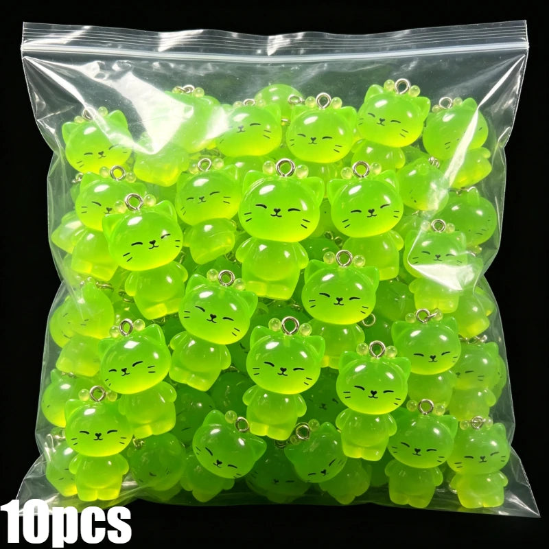 A bag of 10 pairs of glow-in-the-dark resin alien cat and duck charms in bright lime green.