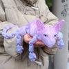 A hand holds a realistic purple Sphynx cat fidget toy with large ears and wrinkled skin.
