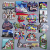 A collection of wooden fridge magnets featuring various destinations like Copenhagen, Hong Kong, Maldives, and Morocco.