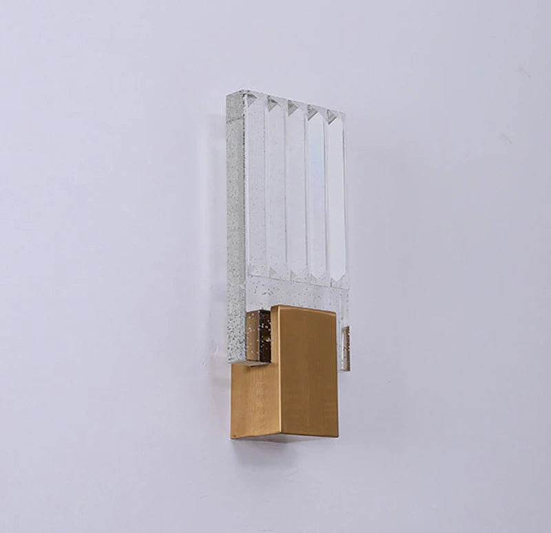 Modern bubble crystal LED wall sconce with a clear glass panel and a brass base.