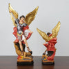 A resin statue of Saint Michael the Archangel with golden wings and armor.