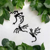 A set of three black dragon metal wall art panels displayed on a white background surrounded by green leaves.