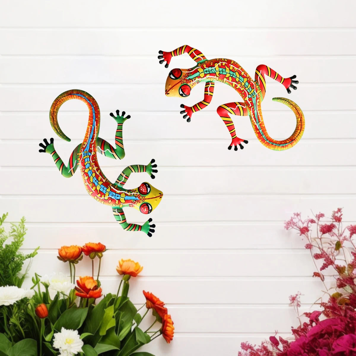 Handcrafted metal gecko wall art featuring colorful, vibrant lizard figures against a white wooden background.