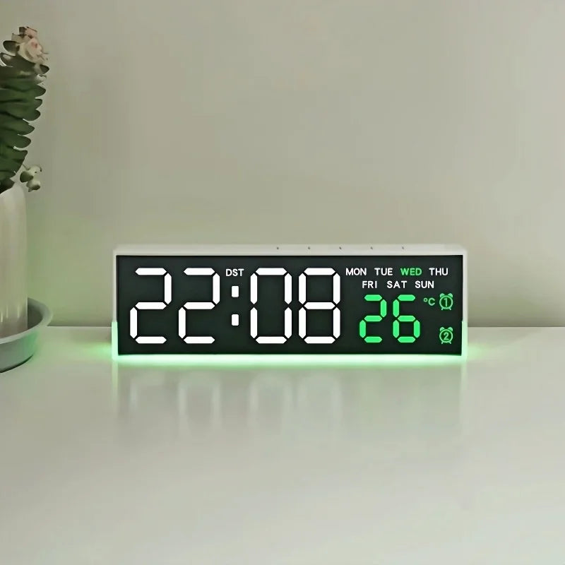 A digital LED alarm clock displaying 22:08 and 26 degrees with a green ambient light on a white surface.