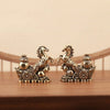 A pair of solid copper horse figurines for prosperity and positive energy resting on a wooden surface.