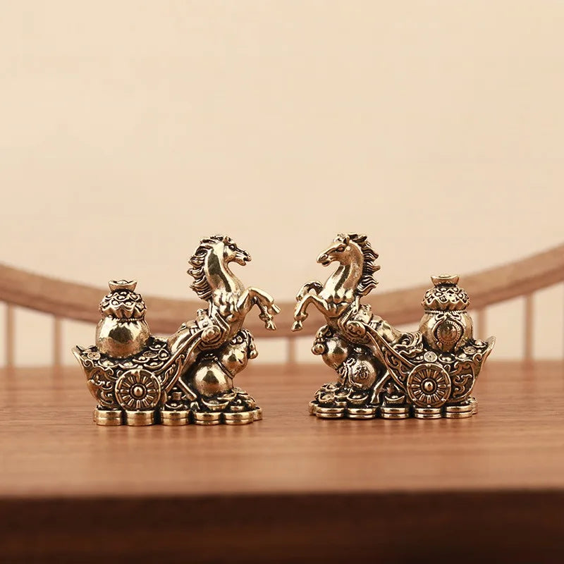 A pair of solid copper horse figurines for prosperity and positive energy resting on a wooden surface.