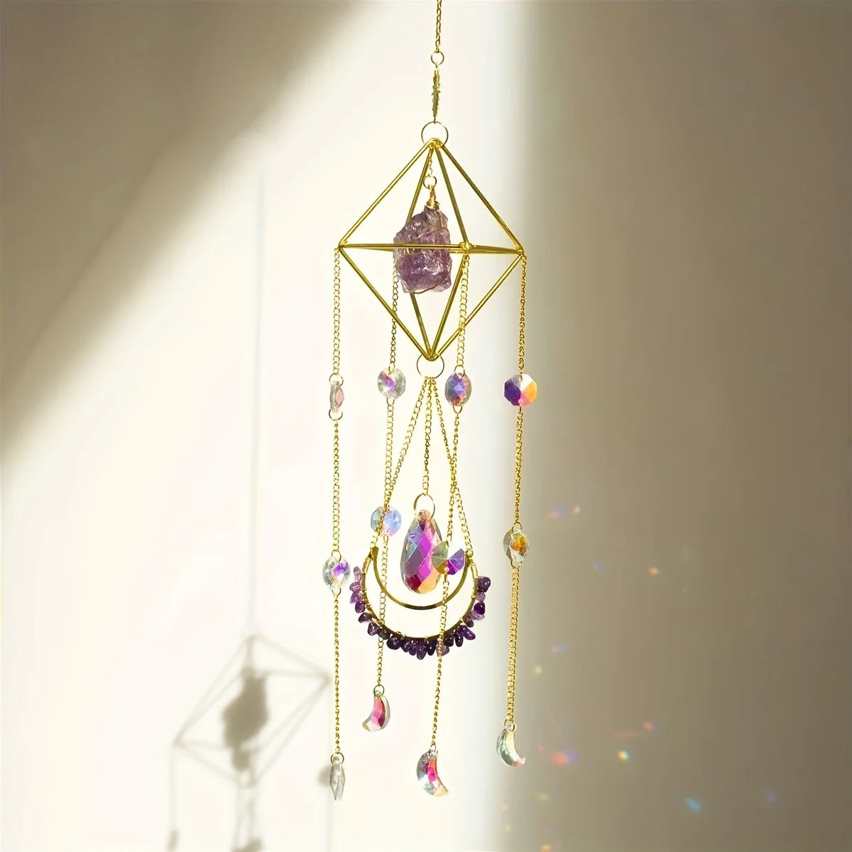 A hanging crystal sun catcher featuring a geometric gold frame and various colored gemstone drops.