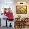 A modern dimmable LED wall lamp with a swing arm is mounted above a bathroom vanity mirror.