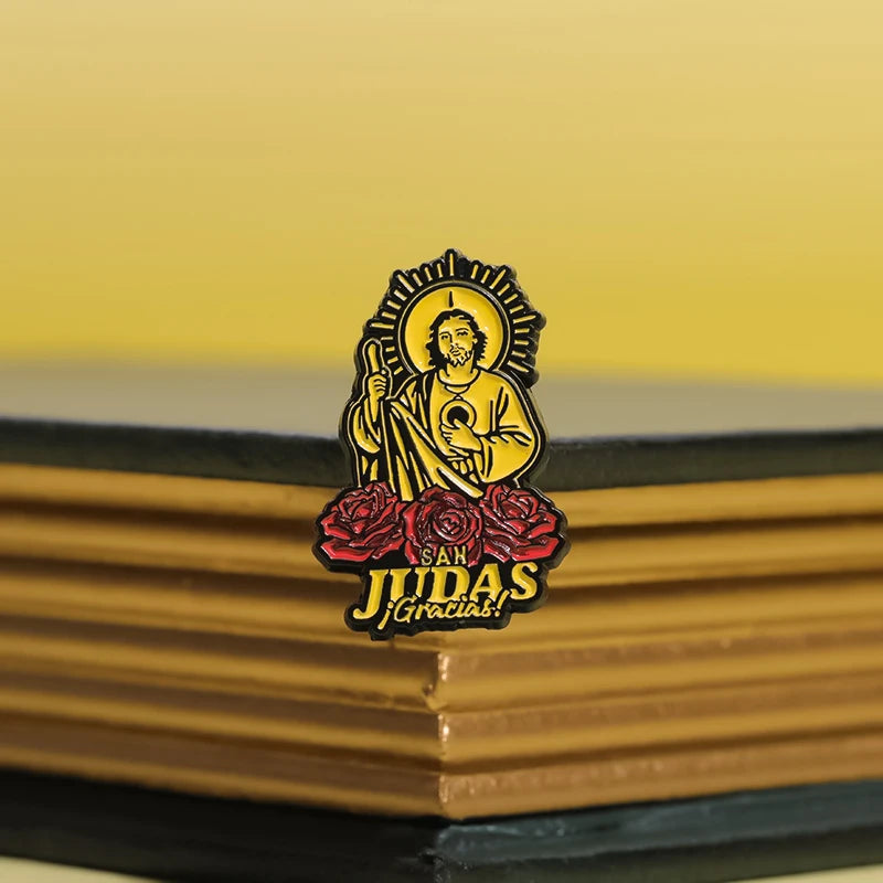 Faith enamel pin featuring a depiction of Saint Judas Tadeo with a halo and a staff on a dark background.