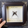 A framed piece of art featuring a dried butterfly specimen with text that reads I could have borne the shade.
