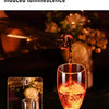Un verre de vin rouge est versé dans un verre à pied, illuminant avec une vive lueur orange.