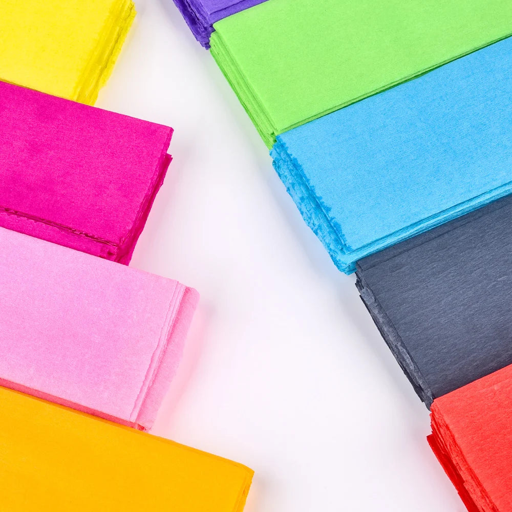 A collection of ten brightly colored crepe paper sheets arranged in a diagonal line.