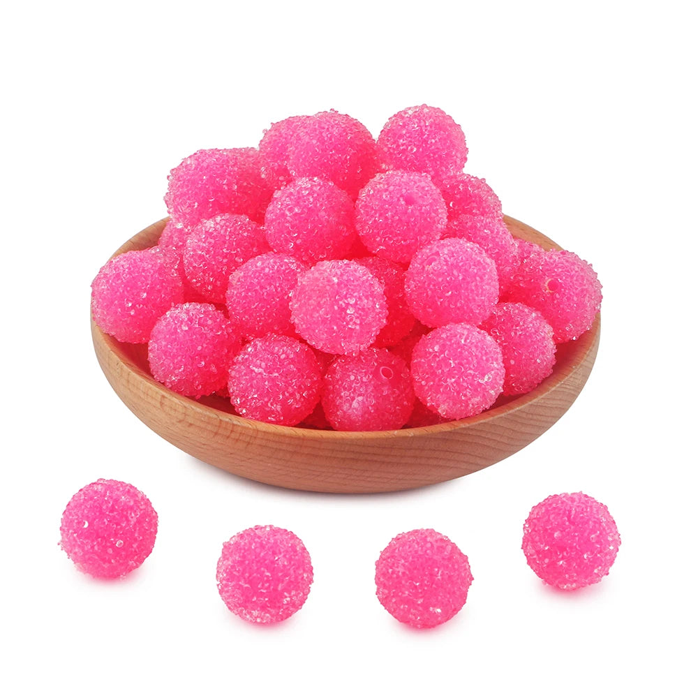 A pile of bright pink textured resin beads for jewelry making
