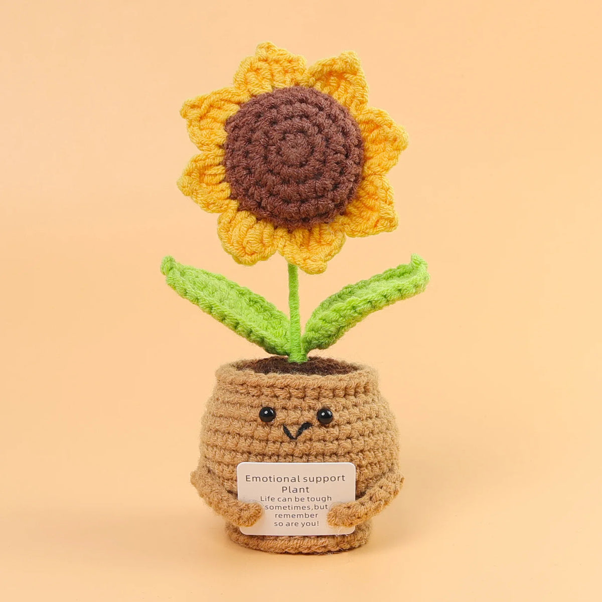 Handmade crochet sunflower desk companion with a smiling face made of yarn.