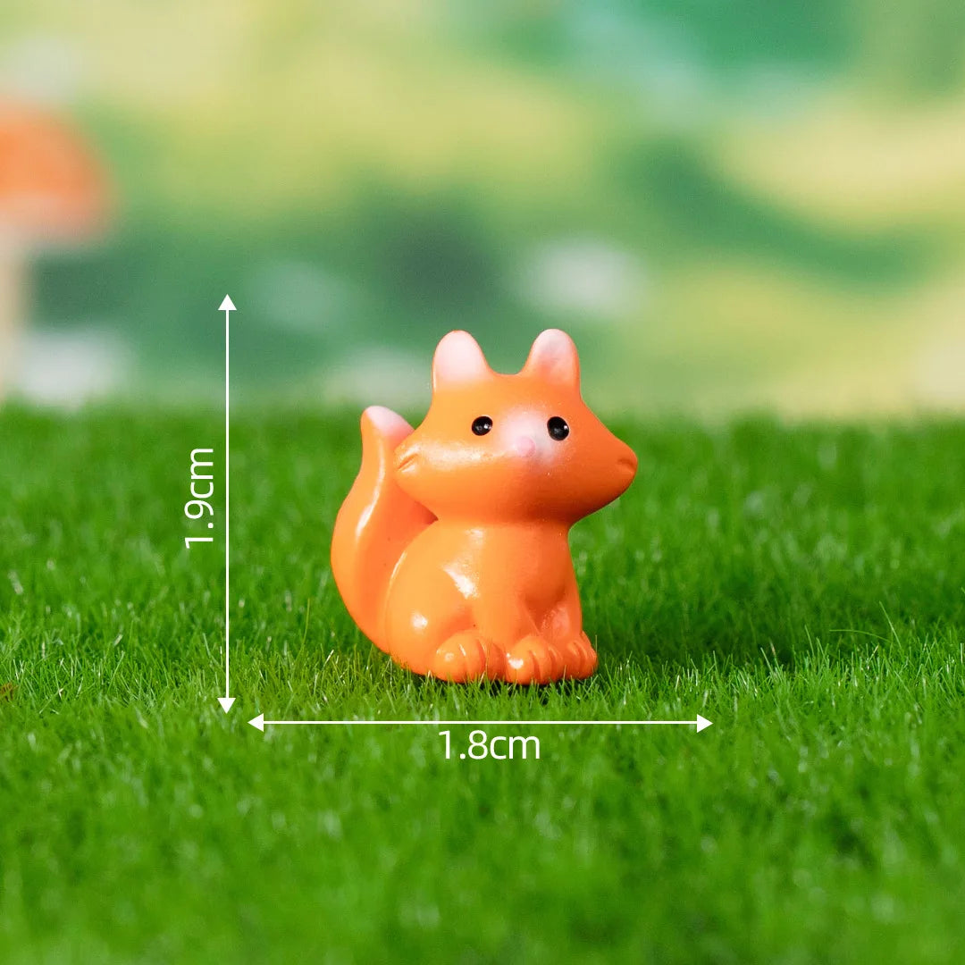 An orange fox figurine is shown on green grass with dimension markings.