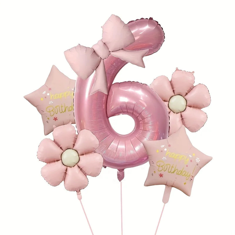 Pink foil balloons shaped like the number six and flowers for a birthday celebration