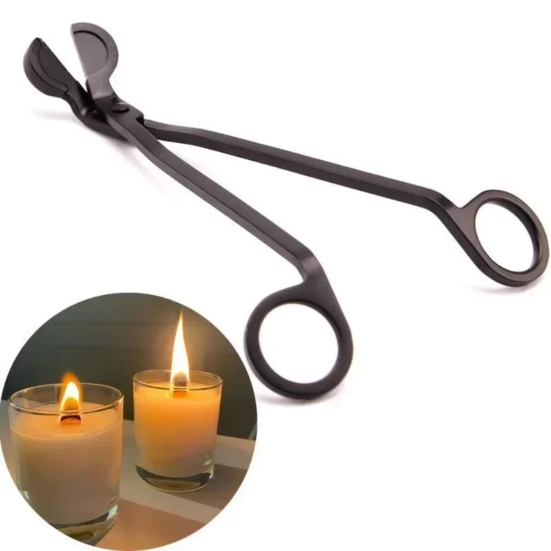 A pair of black stainless steel candle wick trimmer scissors resting above a lit candle.