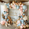 A floral arch made of assorted pastel latex balloons in pink, blue, and gold for a celebration backdrop.