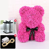 Un ours rose et moelleux en forme de rose avec un ruban noir et une décoration lumineuse LED.