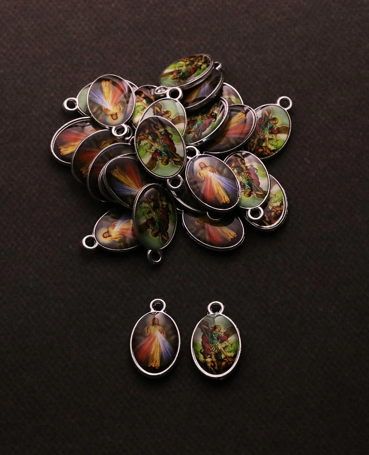 Collection de pendentifs chrétiens ton argentés avec scènes et figures religieuses.