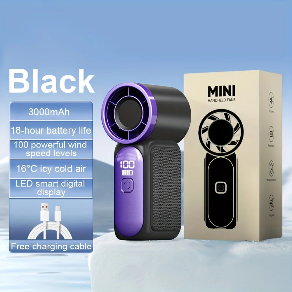 A black portable handheld fan with a purple grille and a beige box is displayed on a snowy surface.