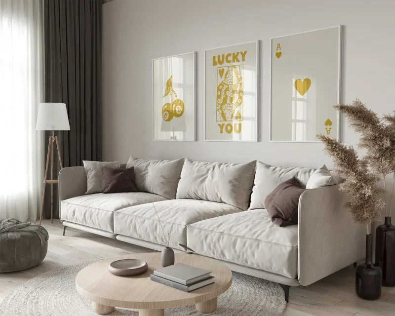 A modern living room features a light sofa and wooden coffee table with a framed lucky letter art canvas set on the wall.