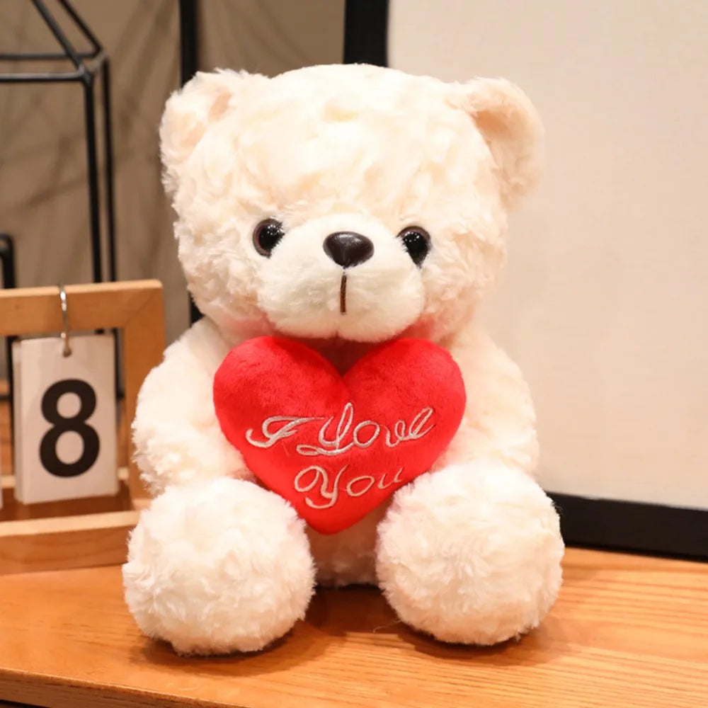 A fluffy white teddy bear plush toy with a red heart stitched onto its chest.