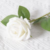 A single white artificial rose with green leaves resting on a white textured fabric.