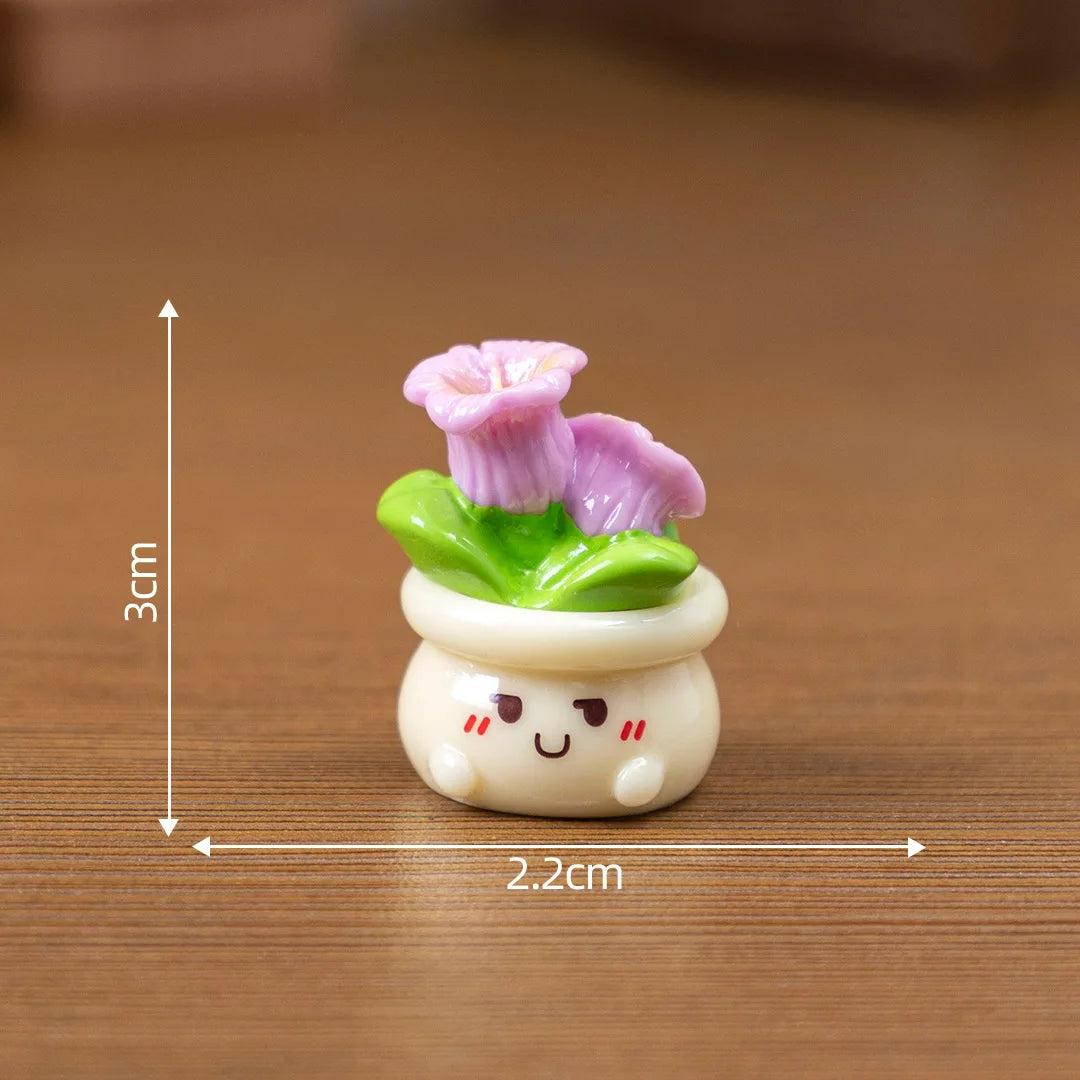 A small resin charm depicting a pink rose growing from a green leaf on a white base.